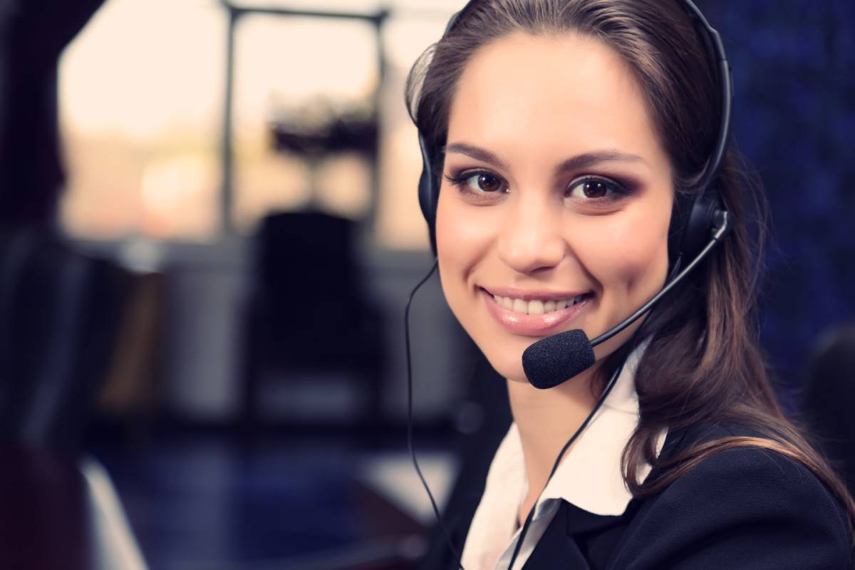 A brunette woman wearing a headset smiling