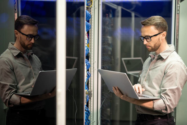 IT Technician with Laptop in Network Server Room