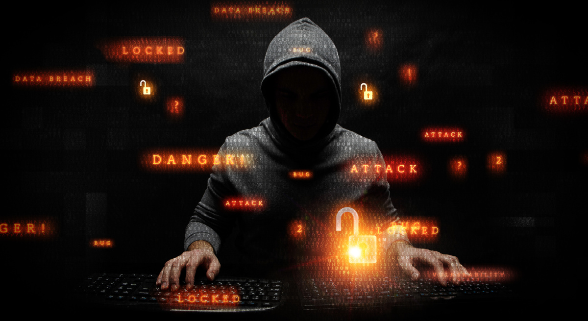 An ominus figure with a hood, typing on two keyboards(cause that's how hacking works I guess), with bright orange text floating around indicating they are hacking
