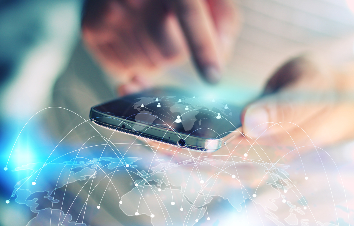 A cellphone being used with an overlay of a globe showing a bunch of dots connected by lines to signify connectivity.