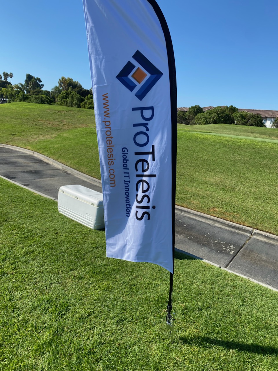 ProTelesis logo flag at the San Ysidro Health's 16th Annual Clasico de Golf tournament.