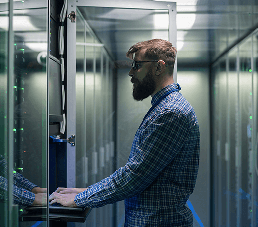 IT Technician Using Laptop in Data Center