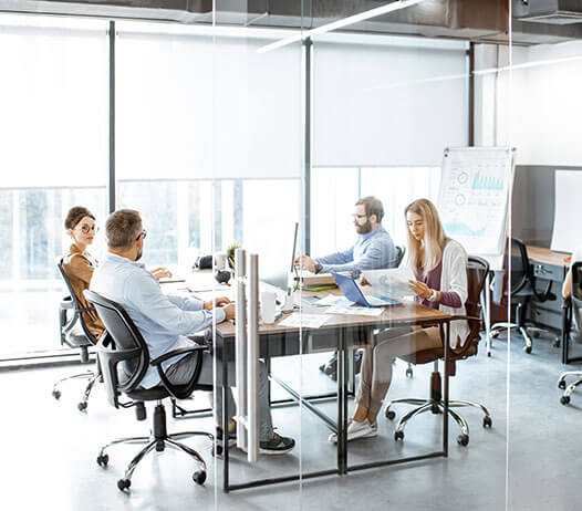 Business People Seated Around Meeting Table in Modern Office