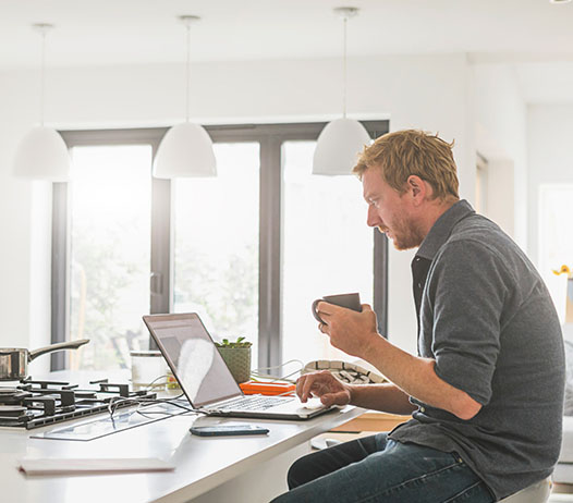 Man on Laptop at Kitchen Counter