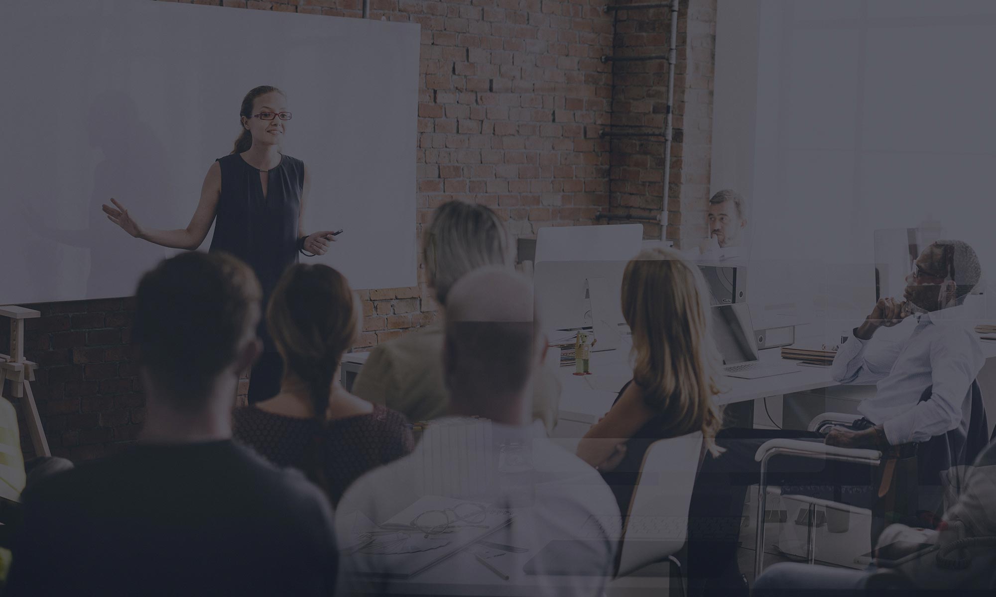 Woman giving a presentation to business colleagues, in front of a white board